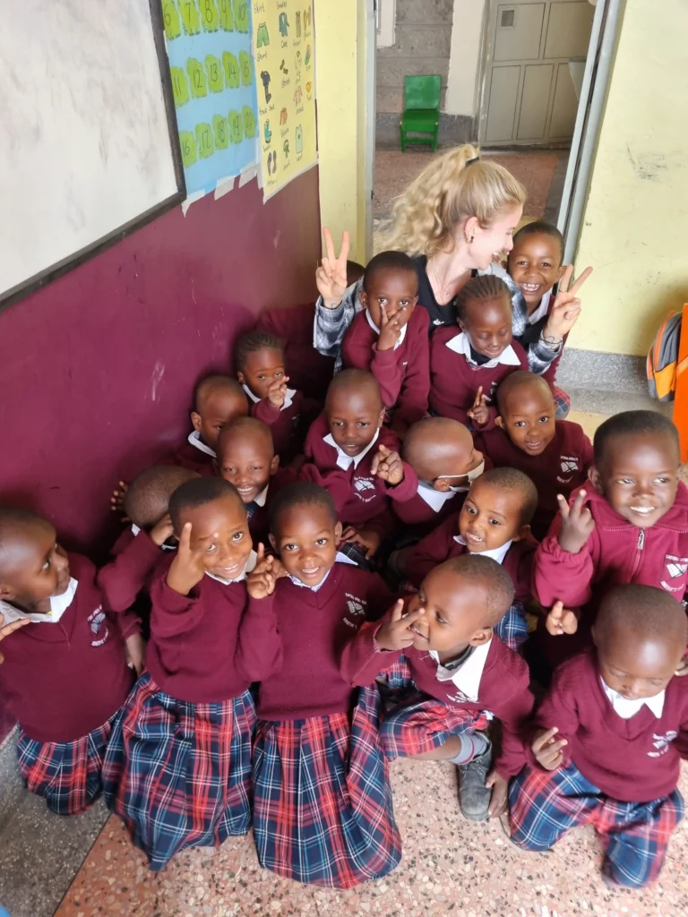 Strahlende Schulkinder posieren fröhlich mit den Supernurses – Bildung und Gesundheit Hand in Hand.